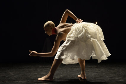 Dancer bent at the waist in a large white skirt.